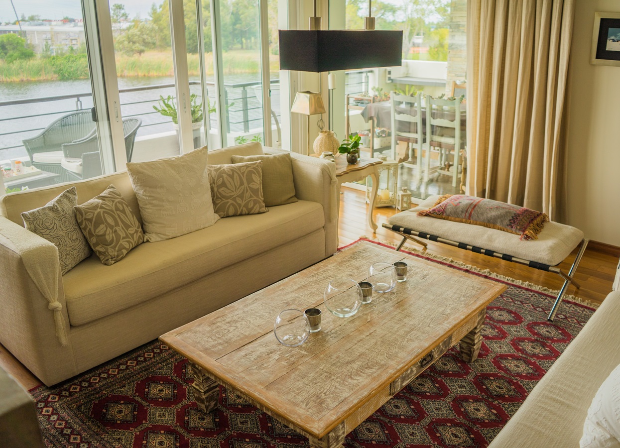 The interior of a modern apartment decorated comfortably with huge windows